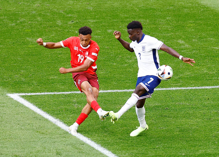 Момент матча между швейцарским футболистом Даном Ндойе и английским игроком Букайо Сакой