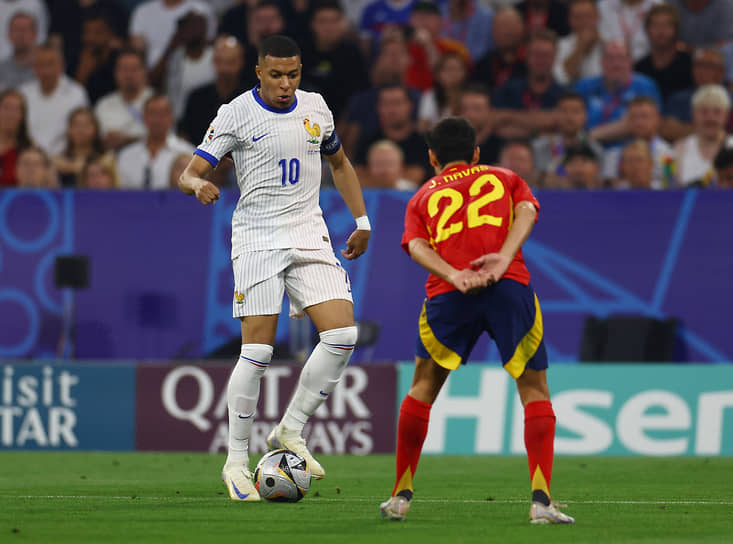 Французский нападающий Килиан Мбаппе обрабатывает мяч перед испанским защитником ХесусомаНавасом (справа)
