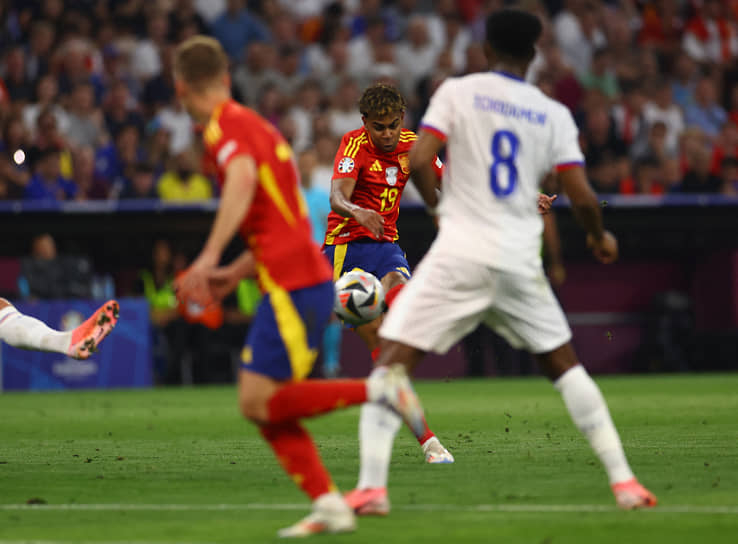 Испанец Ламин Ямаль (в центре) бьет по мячу и открывает счет в матче 
