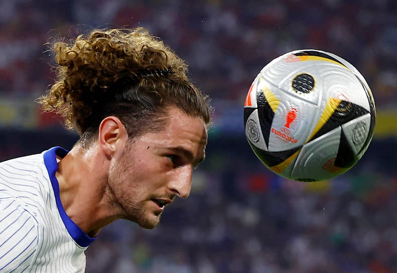 Французский полузащитник Адриен Рабьо принимает мяч головой