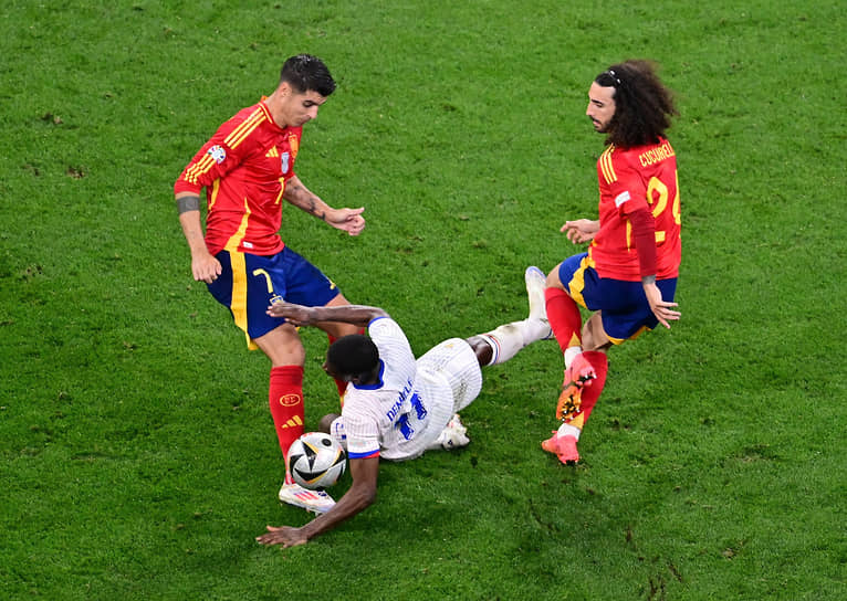 Француз Усман Дембеле (в центре) борется за мяч с испанцами Марком Кукуреллой и Альваро Мората