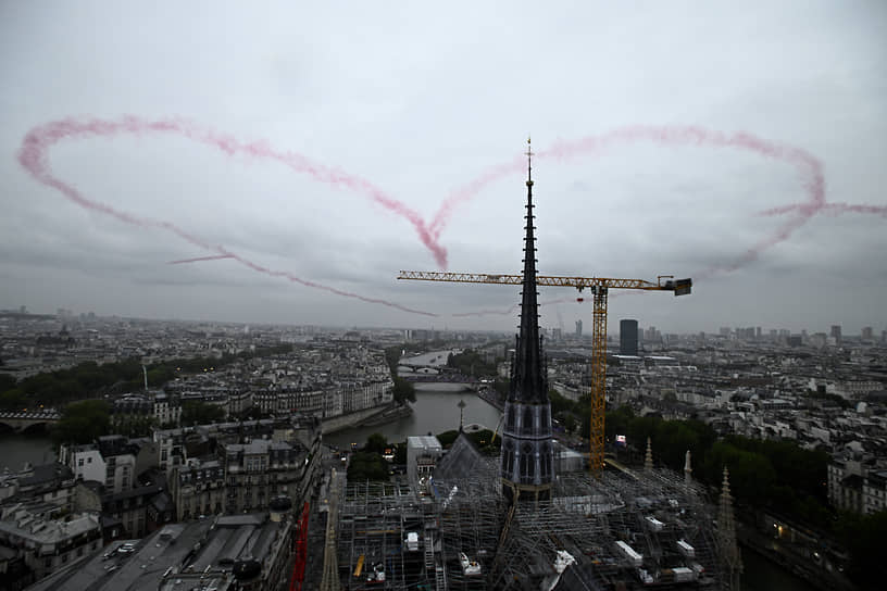 Форма сердца, созданная четырьмя самолетами из красного дыма, около собора Парижской Богоматери