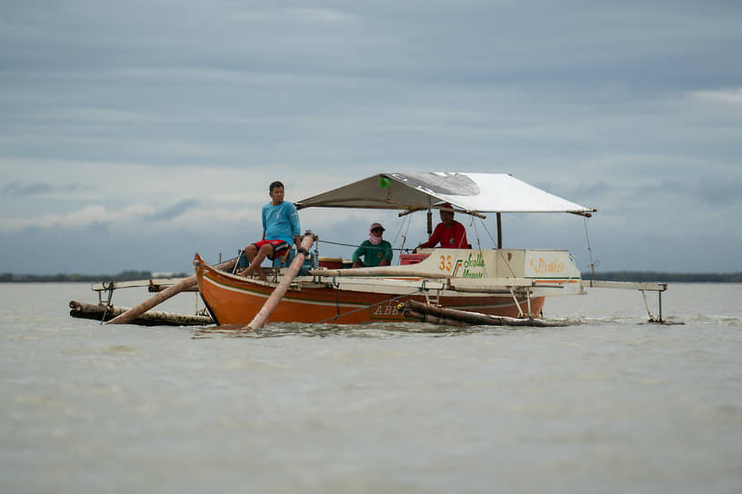 Малолос, Филиппины. Рыбаки отплывают от побережья Манильского залива, куда приблизилось нефтяное пятно от затонувшего танкера 