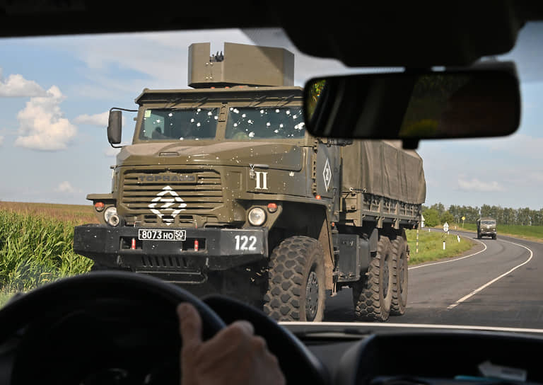 Военные грузовики едут по трассе, соблюдая дистанцию