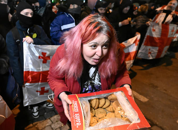 Девушка раздает печенье участникам митинга