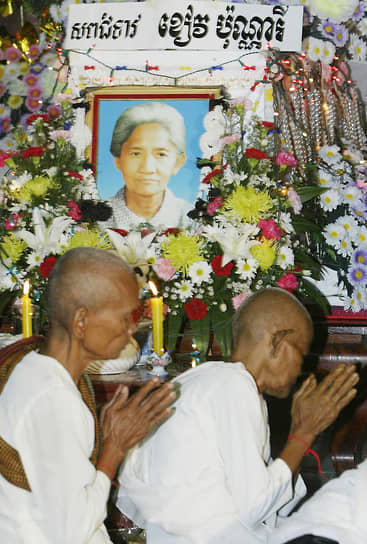 Буддийские монахи молятся у гроба Кхиеу Поннари. В период правления красных кхмеров буддийских монахов называли паразитами и уничтожали, буддистские храмы были закрыты и переоборудованы под другие нужды, предметы культа уничтожены