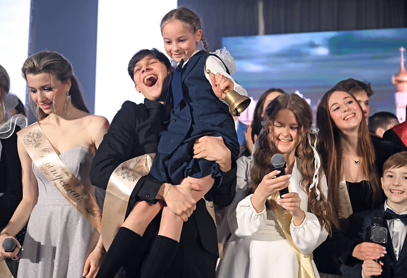 Выпускник с первоклассницей на руках