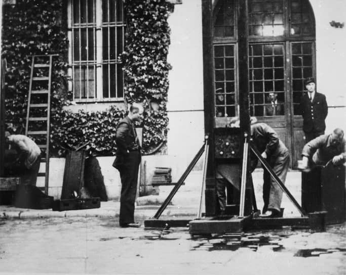 Уборка внутреннего двора тюрьмы после исполнения приговора с помощью гильотины, 1946