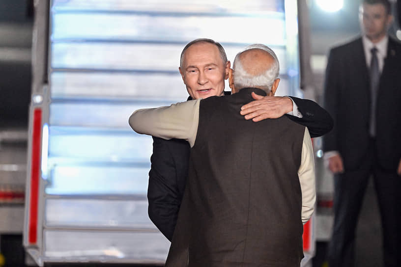 Премьер-министр Индии Нарендра Моди приветствует президента России Владимира Путина у трапа самолета на авиабазе Палам