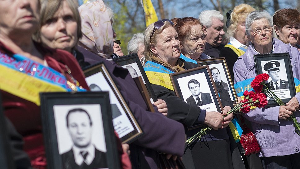 Во время митинга-реквиема в Киевев женщины держат в руках портреты родственников, погибших при ликвидации аварии на Чернобыльской АЭС