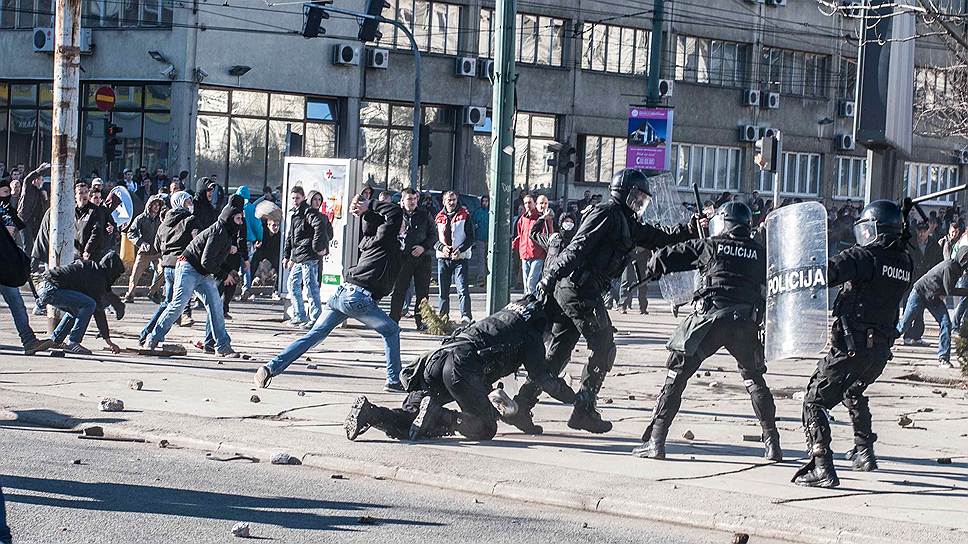 Протестующие бросают камни в полицейских в Сараево