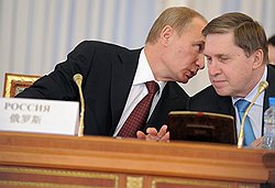 Председатель Правительства России Владимир Путин (слева) и заместитель руководителя аппарата правительства РФ Юрий Ушаков (справа) на заседании Совета глав правительств госудаств-членов ШОС в Константиновском дворце 