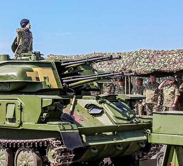 Президент Украины Петр Порошенко (второй справа) готовит план «мирной реинтеграции» Донбасса, но при этом не забывает инспектировать новую военную технику
