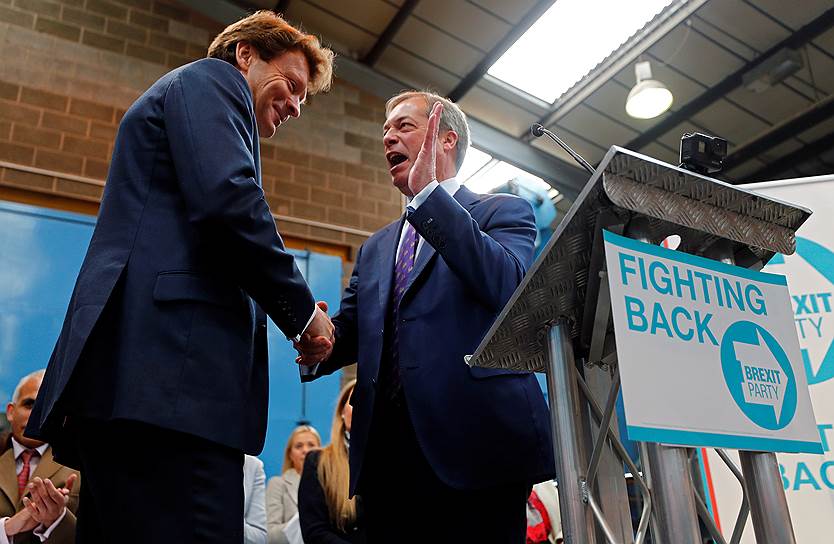 Британский политик Найджел Фарадж (справа) жмет руку бизнесмену Ричарду Тайсу