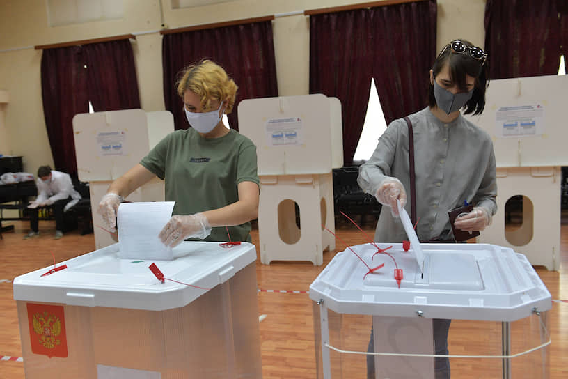Люди во время голосования на избирательном участке