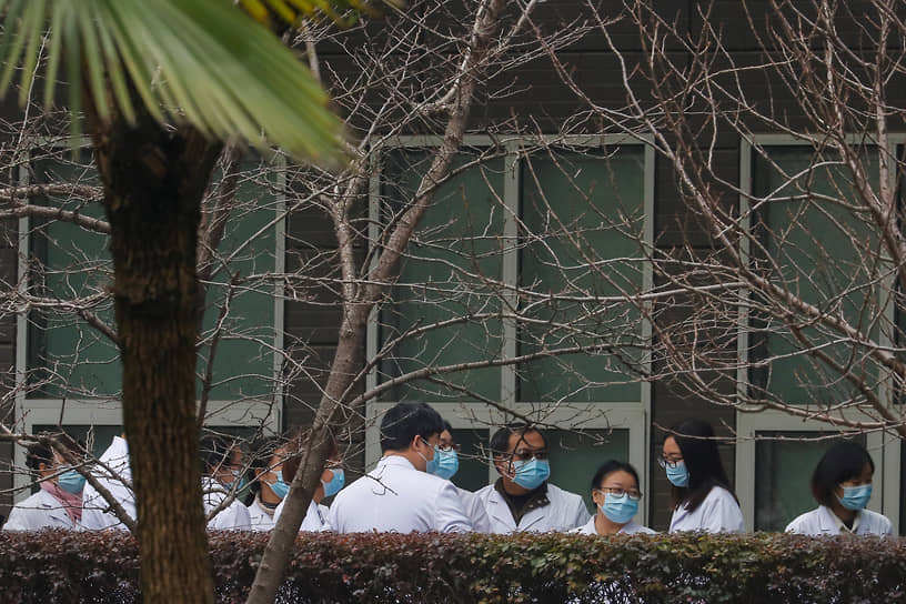 Китайские ученые и чиновники возле хубэйского центра по контролю и предотвращению заболеваний у животных