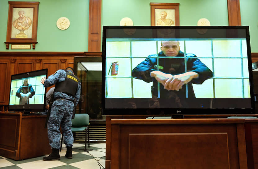 Согласно решению Мосгорсуда, Алексей Навальный (на экране) задержится в колонии еще на девять лет