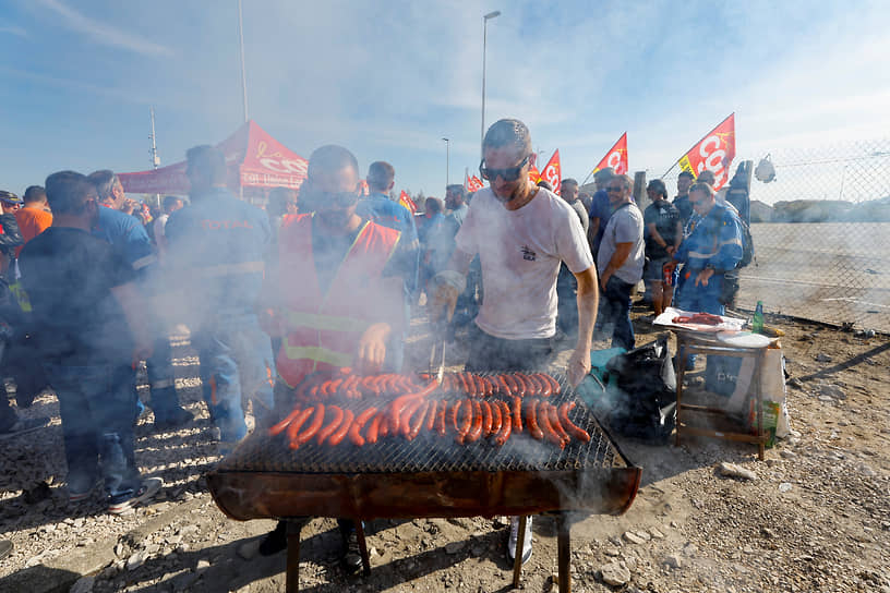 Демонстранты готовят сосиски во время забастовок около заводов Esso-ExxonMobil и TotalEnergies
