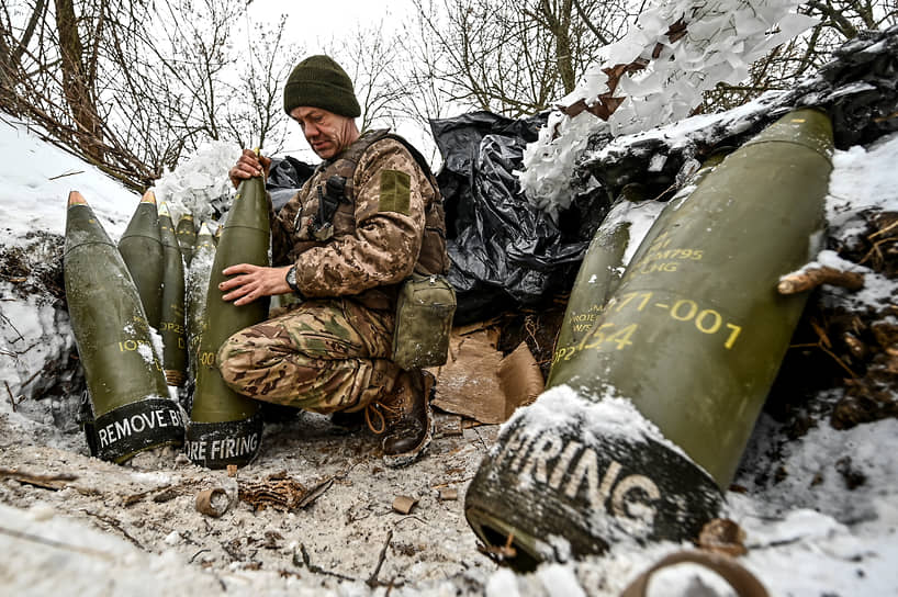 Солдат ВСУ осматривает 155-миллиметровые артиллерийские снаряды на огневой позиции в Запорожской области (январь 2024 года)