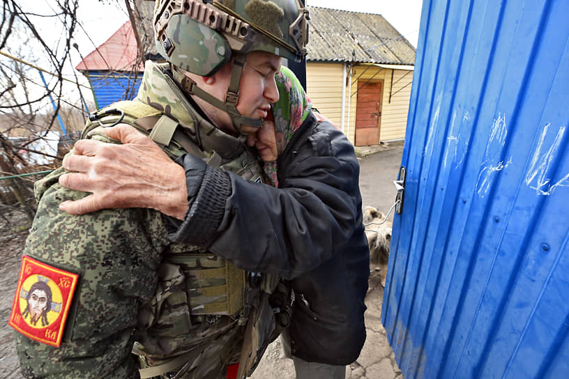 Российский военнослужащий и местная жительница в деревне Зазулевка.