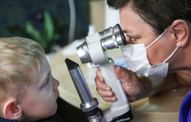 Детский офтальмолог осматривает ребенка