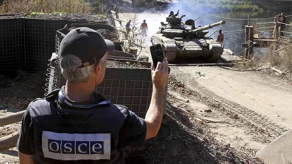 Европейцы из миссии ОБСЕ находятся на обеих сторонах конфликта в Донбассе. На фото: наблюдатель ОБСЕ фиксирует ввод украинских танков