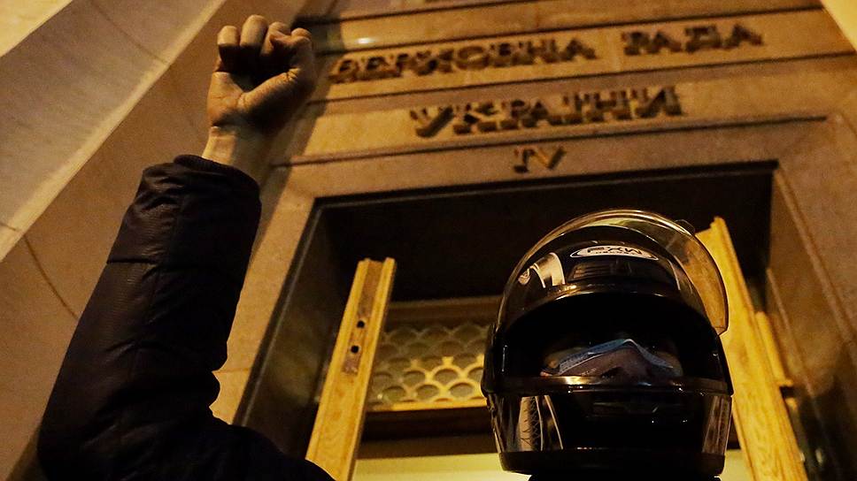 Активист самообороны Евромайдана охраняет здание Верховной рады Украины во время заседания. 
