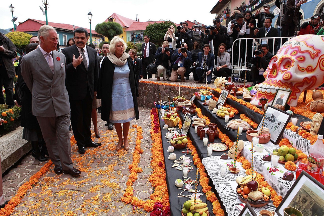 Принц Чарльз Уэльский (слева) и его жена Камилла герцогиня Корнуоллская (справа) посещают алтарь в День мертвых в городе Пачука в штате Идальго, Мексика, во время официального визита