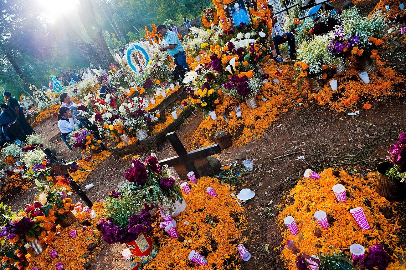 Мексиканские семьи собираются на кладбище, принося цветы и еду, чтобы почтить память  умерших родственников во время празднования Дня мертвых в Цурумутаро, Мичоакан, Мексика
