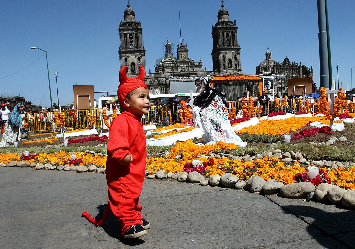 Мальчик в костюме чертенка на площади Cокало во время празднования Дня мертвых в Мехико