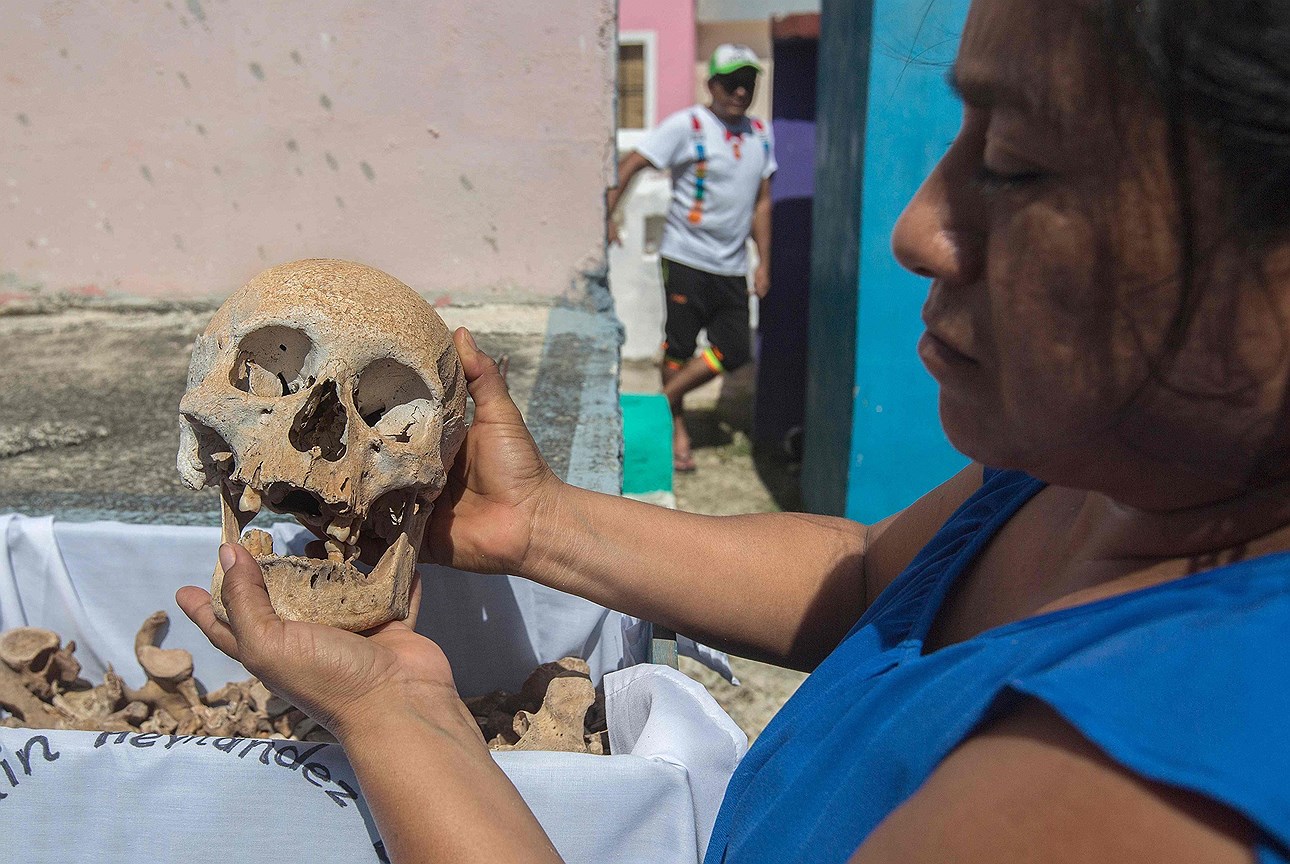 Женщина очищает кости любимого человека в День мертвых, в поселке Помуч, штат Кампече, Мексика