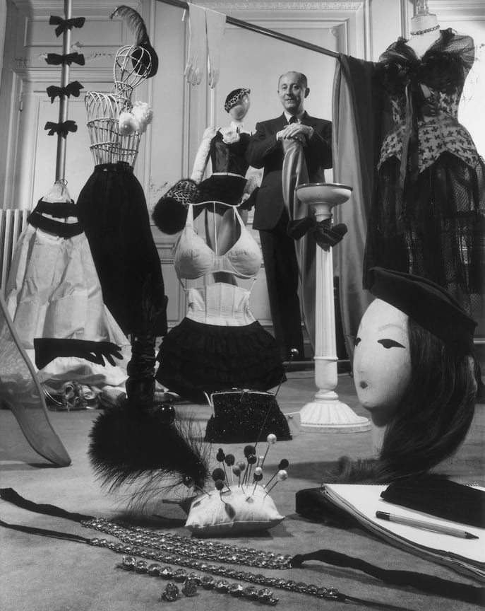Кристиан Диор в выставочном зале с образцами своих дизайнерских аксессуаров для женщин, включая шляпы, шляпные булавки, перчатки, муфты, нижнее белье,  вечерние сумки и ювелирные изделия, 1955 год