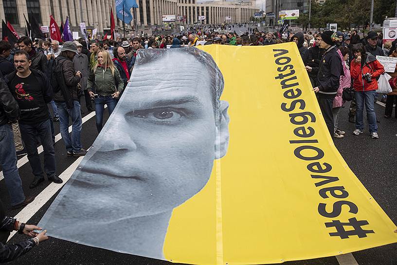 Протестующие держат плакат с изображением Олега Сенцова во время митинга оппозиции, организованного «Свободной Россией» в Москве