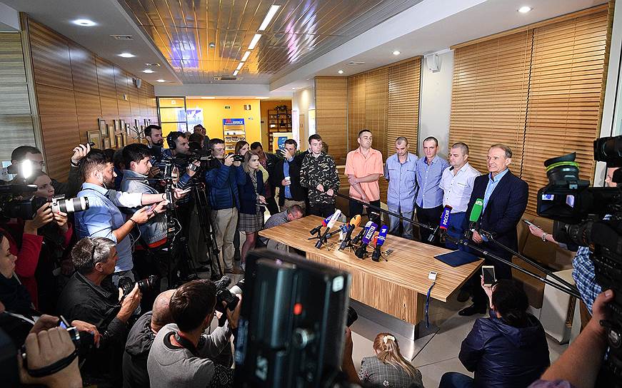 Глава политсовета партии «Оппозиционная платформа — за жизнь» Виктор Медведчук (справа) и удерживавшиеся в ДНР и ЛНР украинцы