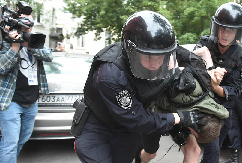 Полицейские задерживают одного из протестующих 