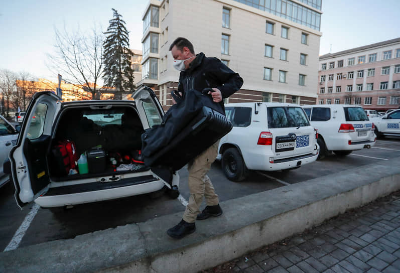 Сотрудник ОБСЕ грузит багаж в автомобиль