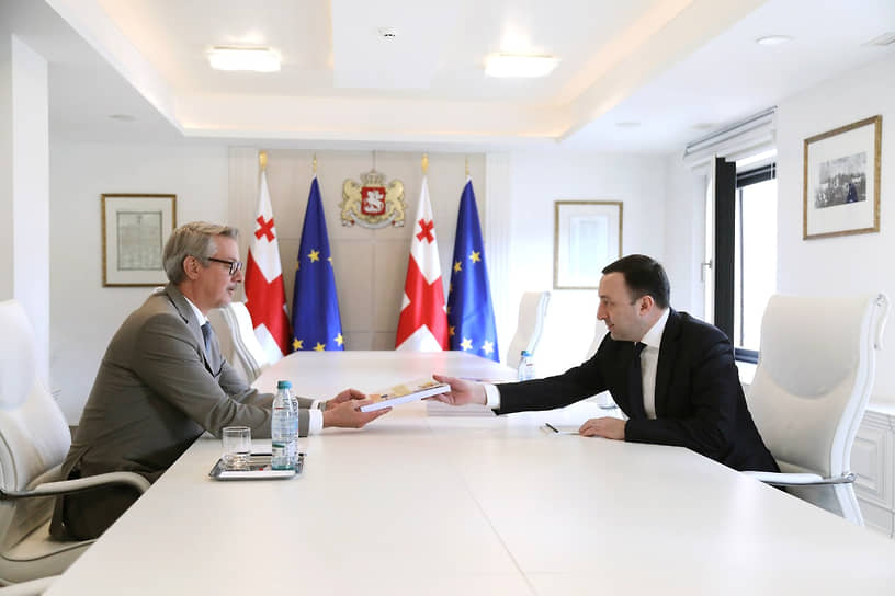 Премьер-министр Грузии Ираклий Гарибашвили (справа) передал европейскому послу Карлу Хартцелю вторую и заключительную часть анкеты-опросника