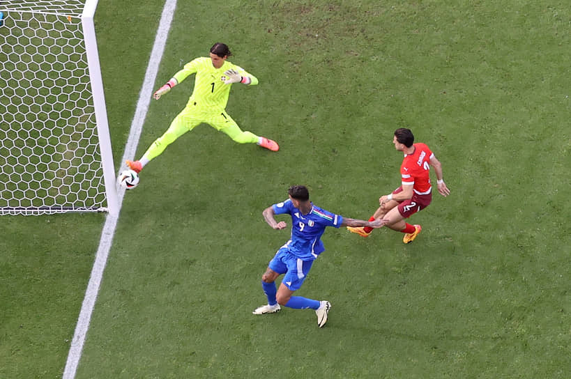 Итальянец Джанлука Скамакка (в синей форме) наносит удар по воротам сборной Швейцарии