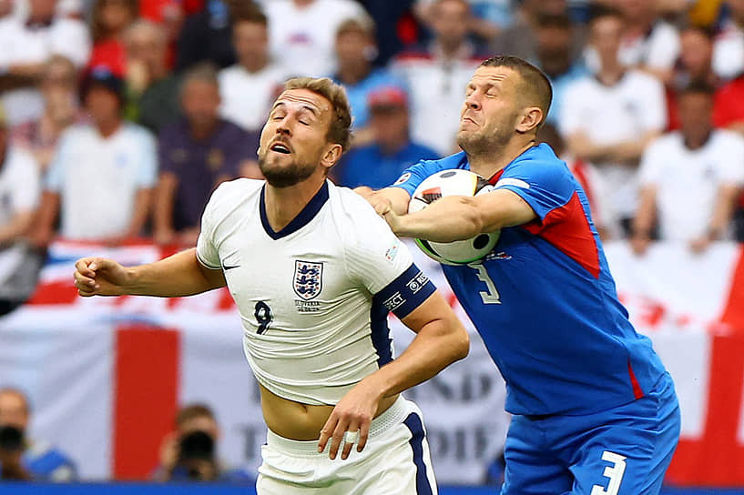 Английский нападающий Гарри Кейн борется за мяч со словацким защитником Денисом Вавро