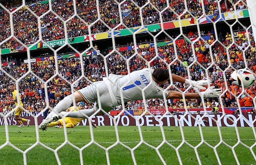 Нападающий сборной Нидерландов Коди Гакпо забивает первый гол в ворота румынского вратаря Флорина Ниты