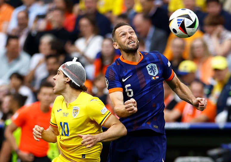 Румынский полузащитник Янис Хаджи (слева) борется за мяч с футболистом сборной Нидерландов Стефаном де Вреем