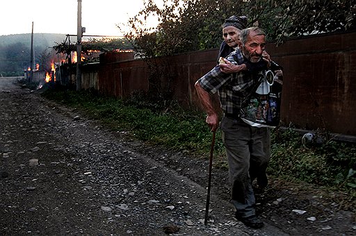 Южная Осетия: сосед грузинки Варвары Гогидзе переносит ее из дома, подожженного мародерами. 1-е место в номинации «Новости. Истории» 