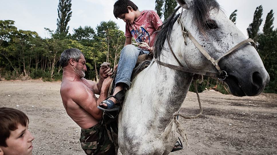 Братья седлают коня в Сарыкуме, одном из самых жарких мест в Дагестане
