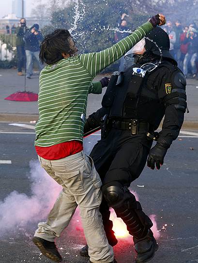 План на 18 марта (опубликован на сайте Blockupy) был самый что ни на есть мирный. В 7:00 активисты должны были встать (и сесть) на подступах к ЕЦБ под музыку и представления уличных театров. В полдень намечалась манифестация немецких профсоюзов, в 17:00 — общая демонстрация, еще через два часа — разъезд по домам. Но протестующие пришли с другим настроем. Столкновения с полицией начались с раннего утра 