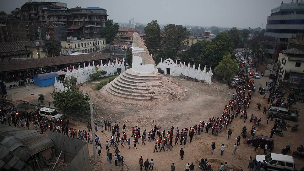 Чтобы почтить память жертв землетрясения 25 апреля, непальцы со свечами собираются у руин башни Дхарахара