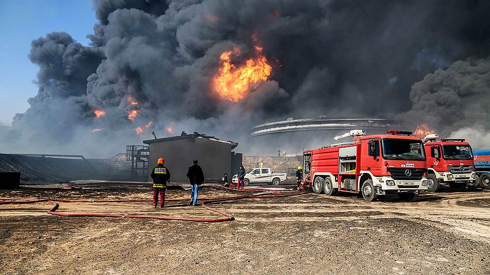 Визитные карточки новой Ливии через пять лет после Каддафи: битва за нефть (на фото -- пожар в главном нефтеналивном порту страны Эс-Сидер после атаки боевиков ИГ)...