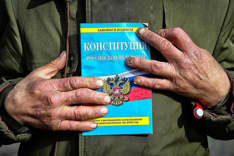 Экскурсовод, знаменитый экс-бездомный Вячеслав Раснер держит в руках Конституцию Российской Федерации