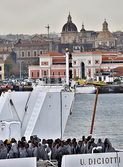 Патрульный катер береговой охраны Италии прибывает в порт Катании. На борту — спасенные беженцы 