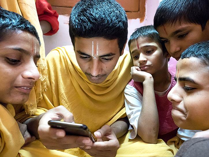 Студенты изучают содержимое айфона, но в большинстве случаев они пренебрегают мирскими благами