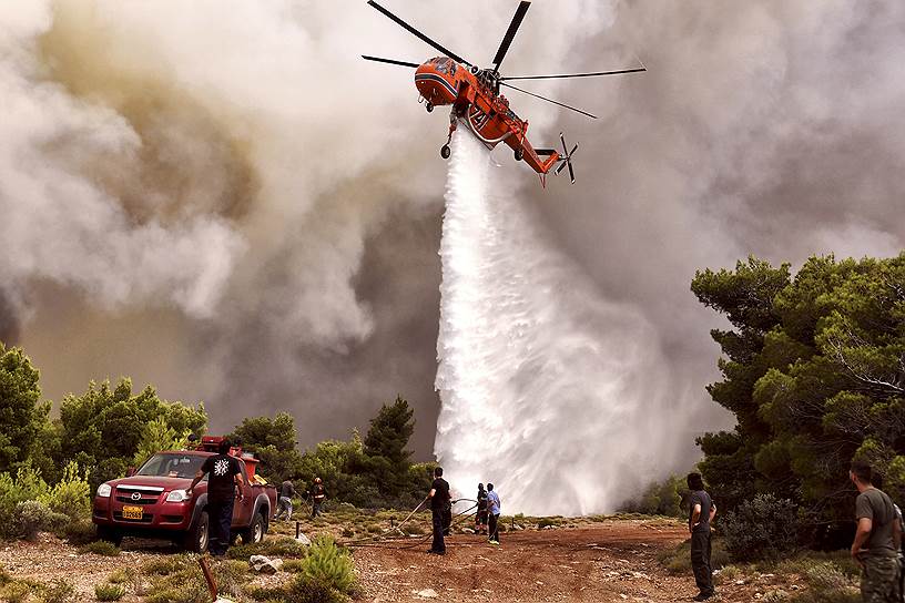 Пожарный вертолет пытается остановить пламя у деревни Кинета в Западной Аттике
